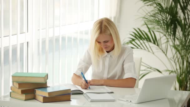 Leuk meisje, zittend bij tabel schrijven — Stockvideo