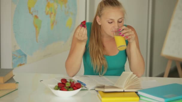 Meisje zitten aan tafel eten aardbei — Stockvideo