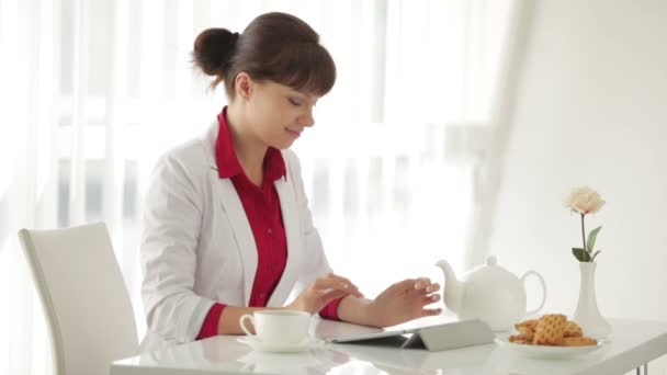 Mulher sentada à mesa com xícara de chá — Vídeo de Stock