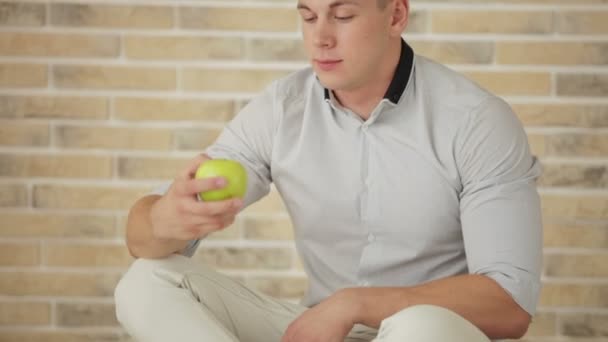 床食用リンゴ上に座って男 — ストック動画