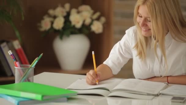 Chica sentada en la mesa con libros — Vídeos de Stock