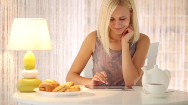 Девушка, сидящая в кафе с помощью тачпада — стоковое видео