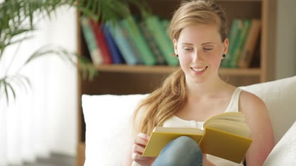 Girl relaxing on couch reading — Stock Video