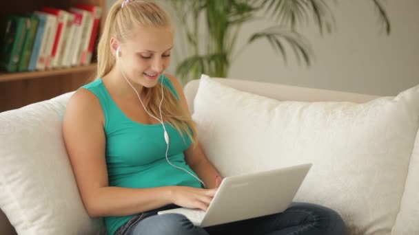 Menina relaxante no sofá com laptop — Vídeo de Stock