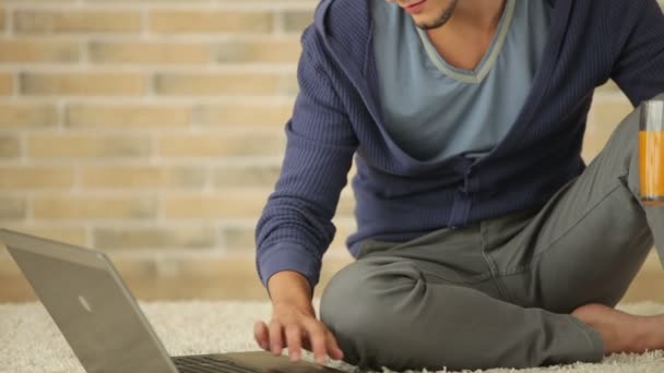 Ragazzo seduto sul pavimento utilizzando il computer portatile — Video Stock