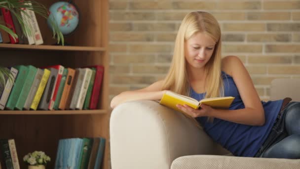 Girl relaxing on sofa reading — Stock Video