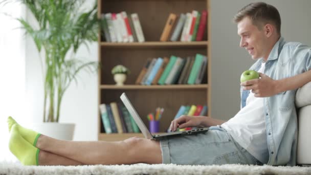 Ο άνθρωπος κάθεται στο πάτωμα χρησιμοποιώντας φορητό υπολογιστή — Αρχείο Βίντεο