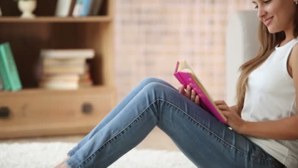 Chica sentado en piso lectura libro — Vídeo de stock