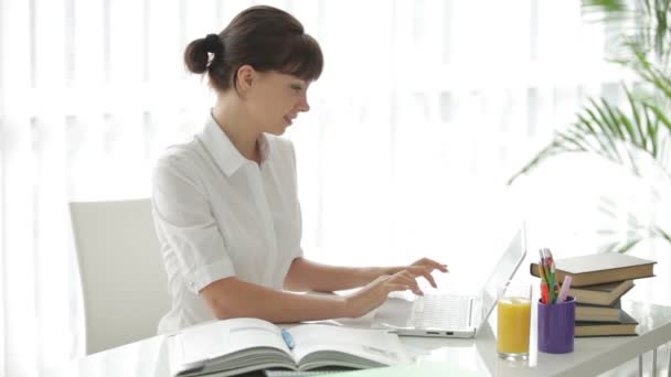 Mujer sentada en la mesa usando portátil — Vídeos de Stock