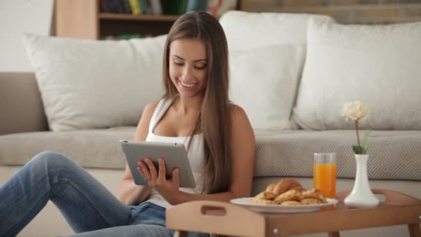 Frau sitzt mit Touchpad auf dem Boden — Stockvideo