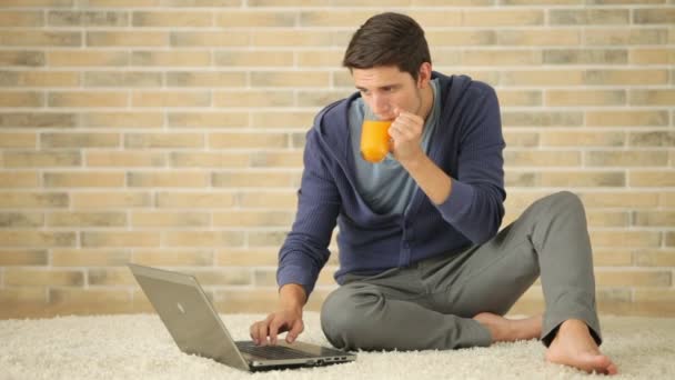 Mann sitzt mit Laptop auf dem Boden — Stockvideo