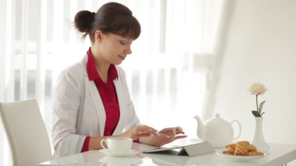 Mujer sentada a la mesa bebiendo — Vídeos de Stock