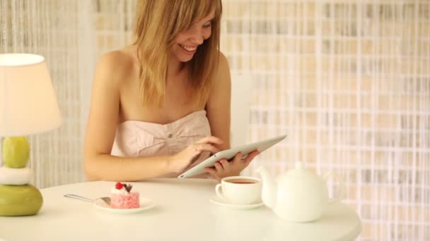 Girl sitting at table using touchpad — Stock Video