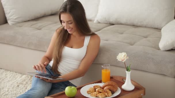 Chica sentada en el suelo usando touchpad — Vídeo de stock