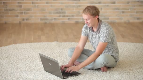 Mann sitzt mit Laptop auf dem Boden — Stockvideo