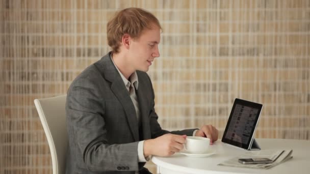 Hombre sentado en la mesa usando touchpad — Vídeos de Stock