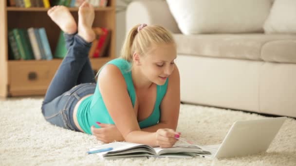 Dziewczyna leży na dywanie przy użyciu laptopa — Wideo stockowe