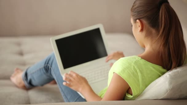 Hübsches brünettes Mädchen sitzt auf Sofa — Stockvideo