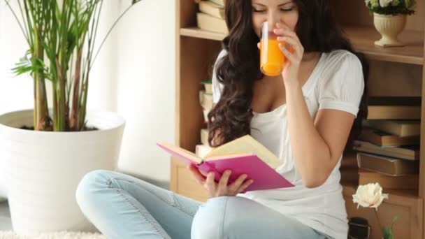 Chica sentado en piso lectura libro — Vídeos de Stock