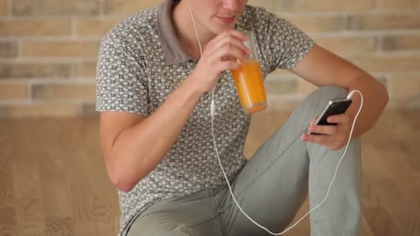 Man wearing earphones sitting on floor — Stock Video