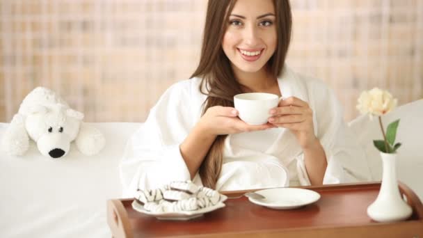 Mujer relajándose en la cama bebiendo té — Vídeo de stock