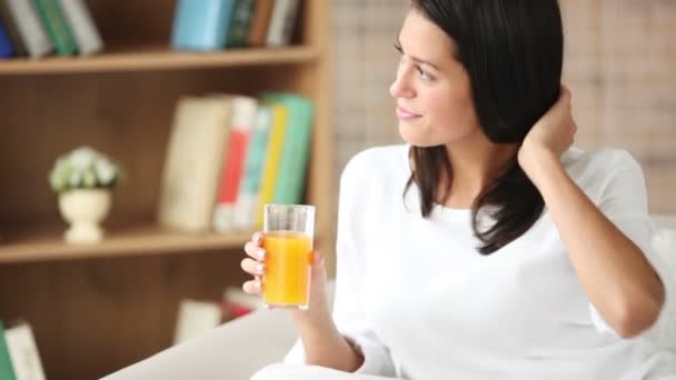 Menina sentada no sofá beber suco — Vídeo de Stock