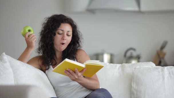 Ragazza agghiacciante sul divano lettura libro — Video Stock