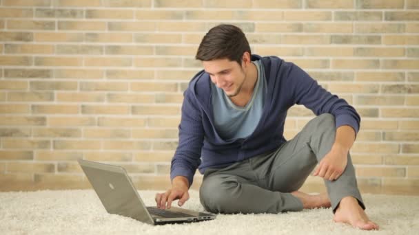 Man zittend op de vloer en met behulp van laptop — Stockvideo