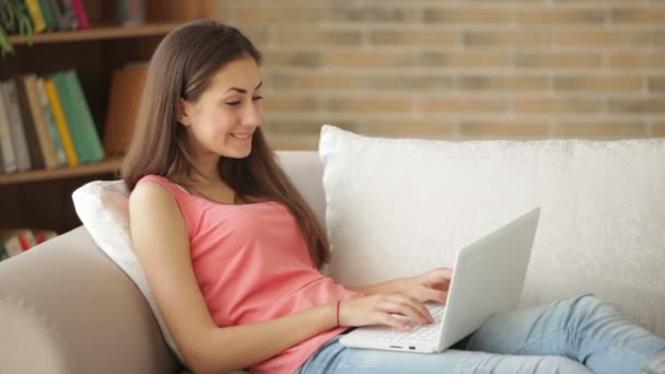 Menina relaxante no sofá usando laptop — Vídeo de Stock