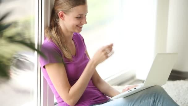 Lány ül, az ablak használ laptop — Stock videók
