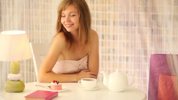 Girl sitting at cafe with book — Stock Video