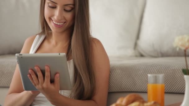 Girl sitting on floor using touchpad — Stock Video