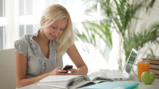 Chica sentada en la mesa con libros — Vídeos de Stock