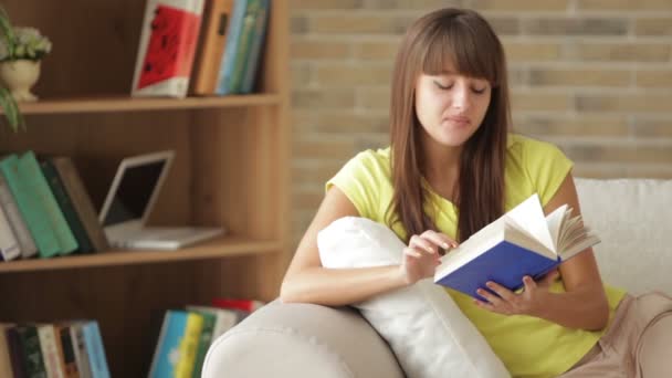 Κοπέλα καθόταν στον καναπέ με το βιβλίο — Αρχείο Βίντεο