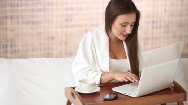 Girl relaxing in bed with cup of tea — Stock Video