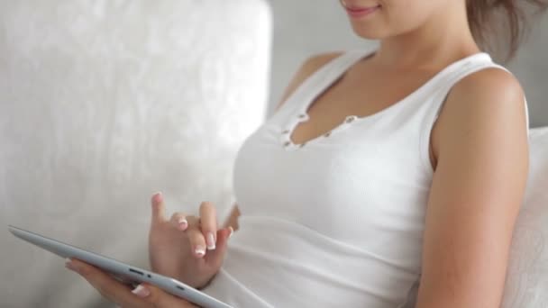 Menina sentada no sofá com touchpad — Vídeo de Stock