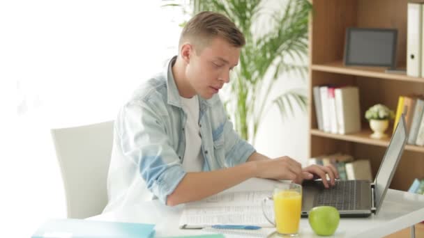 Man zit aan tafel schrijven in notitieblok — Stockvideo