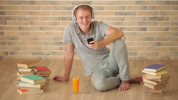 Killen sitter på golvet med mobiltelefon — Stockvideo