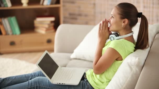 Affascinante ragazza seduta sul divano utilizzando il computer portatile — Video Stock