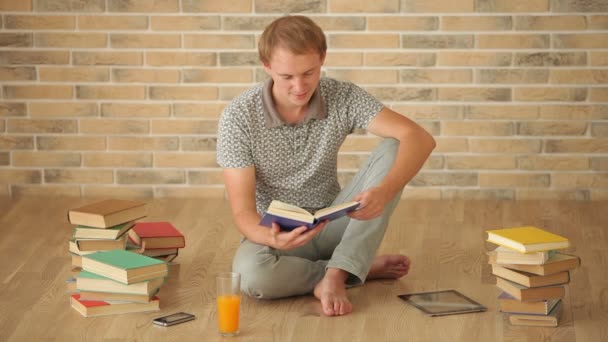 Homem sentado no chão leitura — Vídeo de Stock