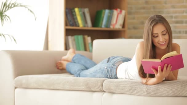 Girl relaxing on couch reading — Stock Video