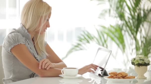 Touchpad kullanarak masada oturan kız — Stok video