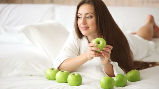 Girl lying in bed with apples — Stock Video