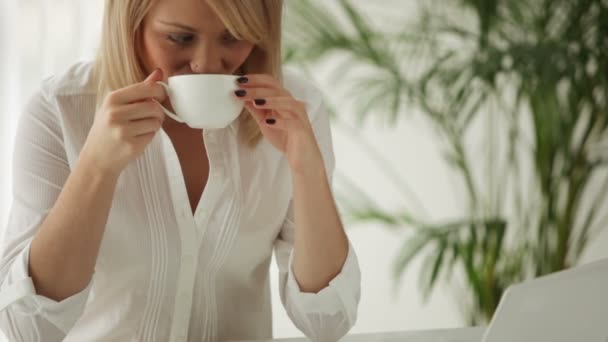 Mujer sentada a la mesa bebiendo café — Vídeo de stock