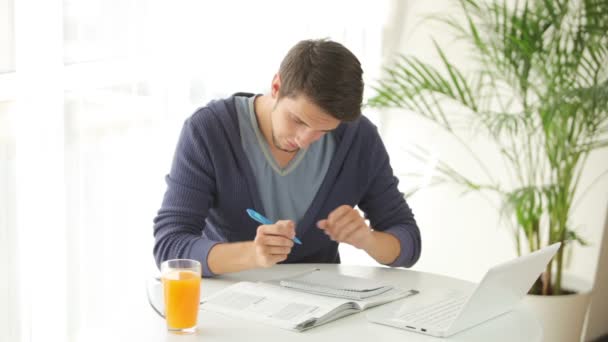 Jovem sentado à mesa e estudando — Vídeo de Stock