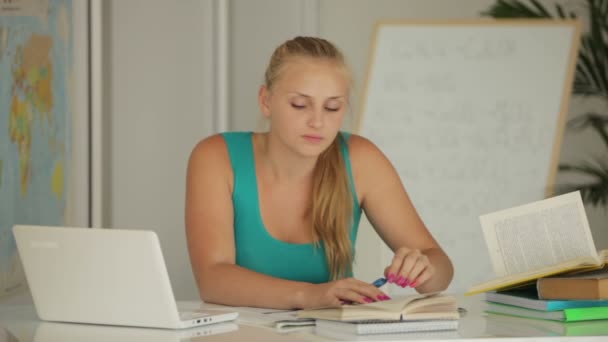 Menina sentada à mesa com notebook — Vídeo de Stock