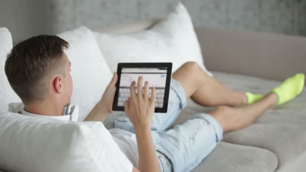 Ember pihentető a kanapéra tabletta. — Stock videók