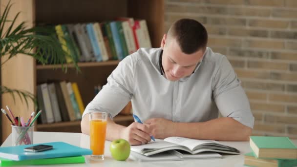 Man zittend aan tafel en schrijven — Stockvideo