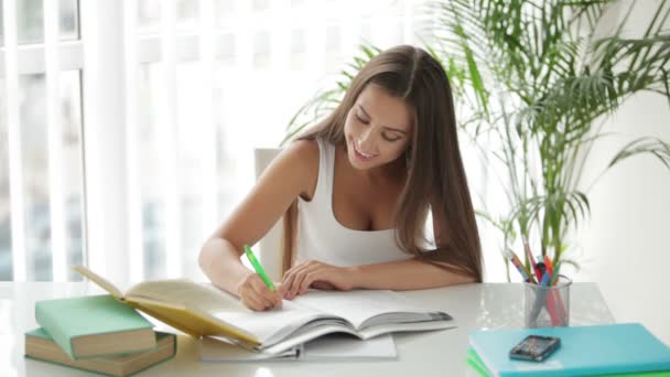 Chica sentada en mesa lectura libro — Vídeos de Stock