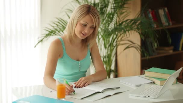 Mooi meisje zittend aan tafel studeren — Stockvideo